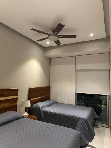 - une chambre avec 2 lits et un ventilateur de plafond dans l'établissement Maritima, à Nuevo Vallarta