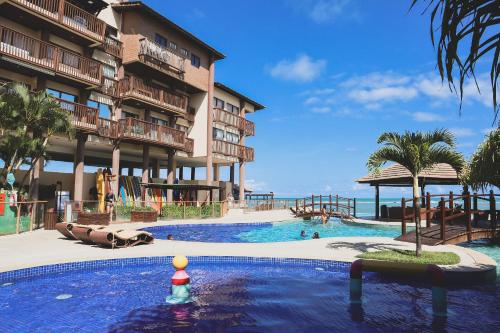 a swimming pool in front of a resort at APARTAMENTO 05 - PÉ NA AREIA - BARRA BALI - AL in Barra de São Miguel