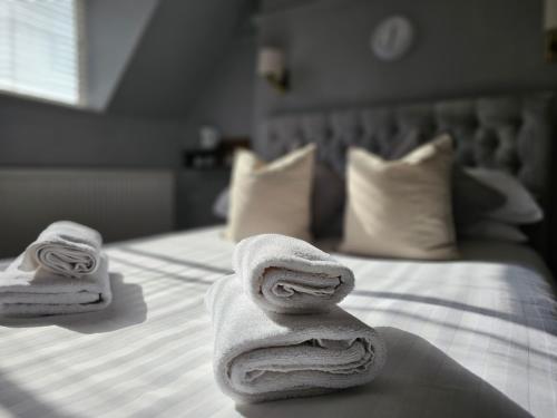two folded towels sitting on top of a bed at Woodfield Accommodation in Chepstow