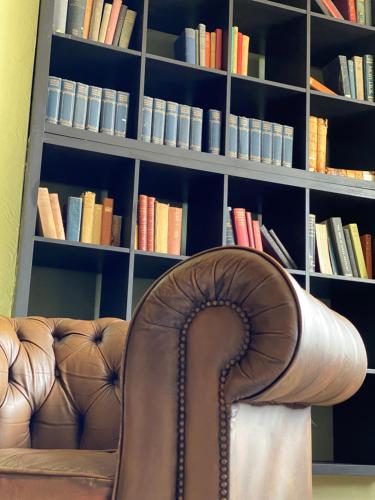 brązowa skórzana kanapa przed półką na książki w obiekcie Woodfield Accommodation w mieście Chepstow