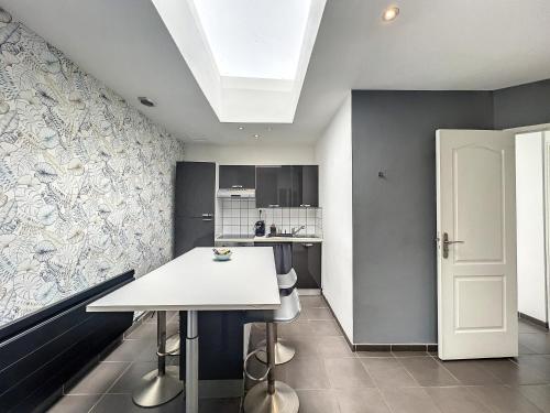 a kitchen with a white table in a room at T2 - parking et jardin privatif in Lambersart