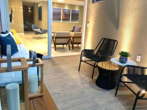 a living room with chairs and a table at APARTAMENTO 05 - PÉ NA AREIA - BARRA BALI - AL in Barra de São Miguel