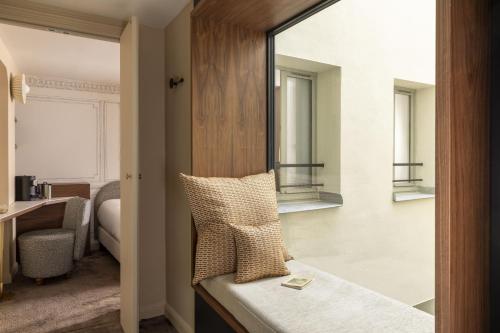 a hotel room with a bed and a mirror at Hotel L de Lutece - Notre-Dame in Paris