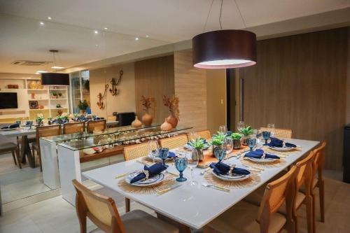 a dining room with a white table and chairs at APARTAMENTO 05 - PÉ NA AREIA - BARRA BALI - AL in Barra de São Miguel
