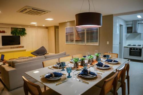 a dining room with a table and a couch at APARTAMENTO 05 - PÉ NA AREIA - BARRA BALI - AL in Barra de São Miguel
