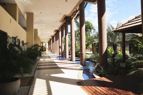 a hallway of a building with columns and plants at APARTAMENTO 05 - PÉ NA AREIA - BARRA BALI - AL in Barra de São Miguel