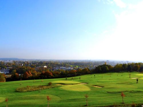 a group of golf courses on a hill with trees at Le Green des Impressionnistes in Ennery