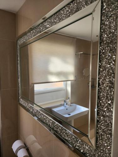 een badkamer met een spiegel en een wastafel bij Belfast Luxury Apartment in Belfast