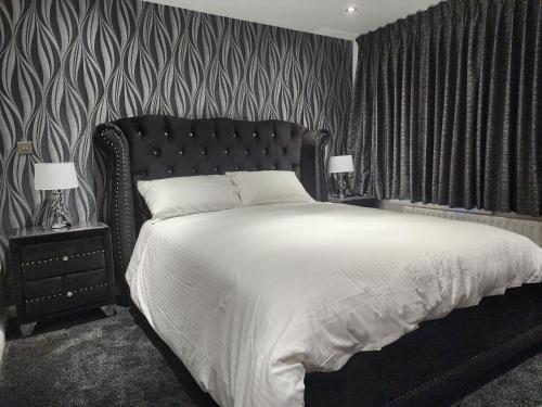 een slaapkamer met een groot bed met een zwart hoofdeinde bij Belfast Luxury Apartment in Belfast