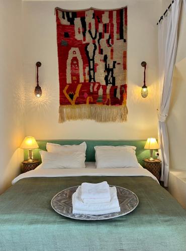 a bedroom with a bed with a tray with towels on it at Riad Tizwa Marrakech in Marrakech