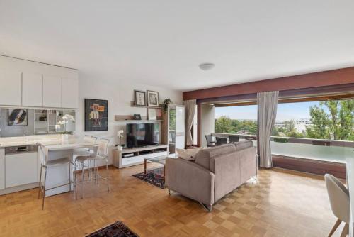 a kitchen and living room with a couch and a table at Tourelle - Appartement moderne dans le centre de Genève in Geneva