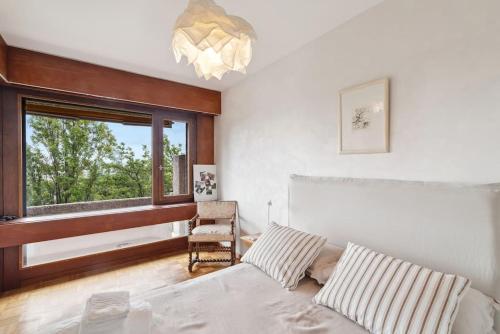a bedroom with a bed and a chair and a window at Tourelle - Appartement moderne dans le centre de Genève in Geneva