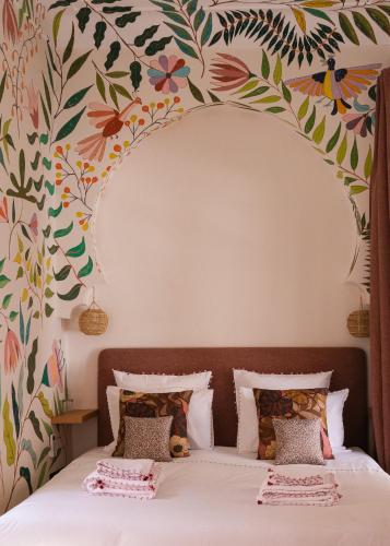 a bedroom with a bed with a floral wallpaper at Riad Pompon in Marrakech