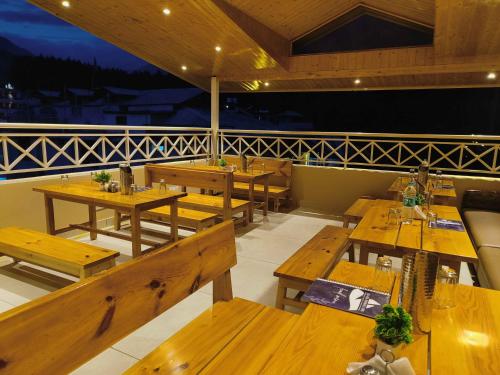 an empty restaurant with wooden tables and benches at Sa-Ba Manali Inn, Mall Road in Manāli