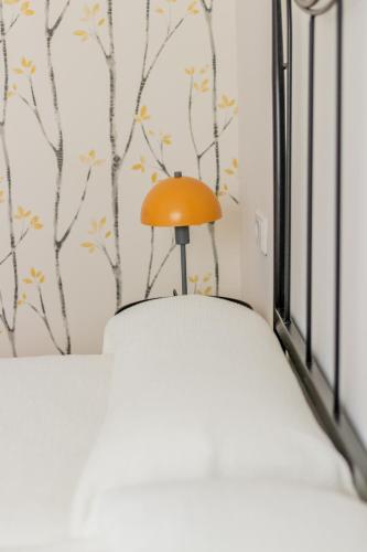 a small orange lamp sitting on top of a bed at Apartamentos Boutique Poniente Playa in San Antonio