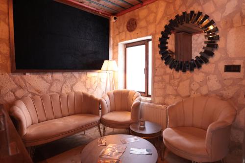 een wachtkamer met lederen stoelen en een spiegel bij Stone Owl Otel & Restaurant in Uchisar