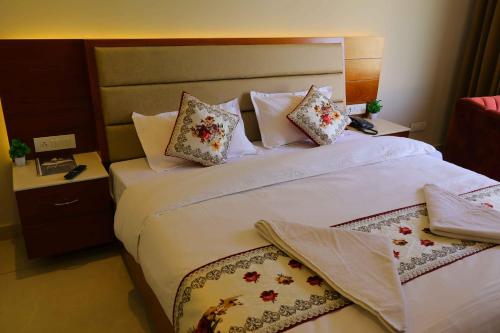 a bedroom with two beds with white sheets and pillows at Sa-Ba Manali Inn, Mall Road in Manāli