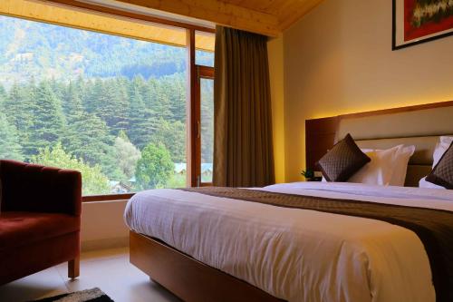 a bedroom with a bed and a large window at Sa-Ba Manali Inn, Mall Road in Manāli