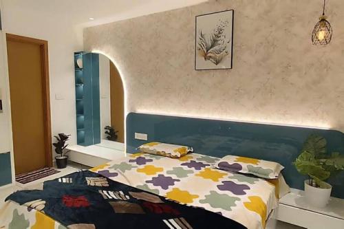 トリバンドラムにあるLuxe Luminar- 1 BHK Apartmentのベッドルーム1室(カラフルな掛け布団付きのベッド1台付)