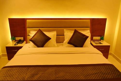a bedroom with a large white bed with pillows at Sa-Ba Manali Inn, Mall Road in Manāli