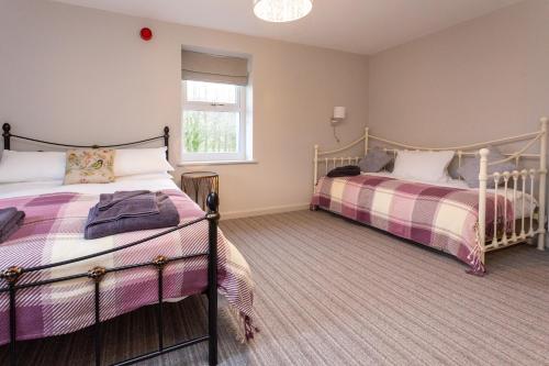 a bedroom with two beds and a window at Howgills House Hotel in Sedbergh