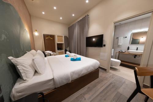 a hotel room with a bed and a bathroom at DOMS Boutique Living in Mellieħa