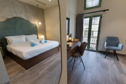 a bedroom with a bed and a desk with a chair at DOMS Boutique Living in Mellieħa