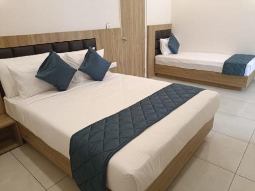 1 dormitorio con 2 camas y almohadas azules en SIGNATURE INN, en Chikmagalur