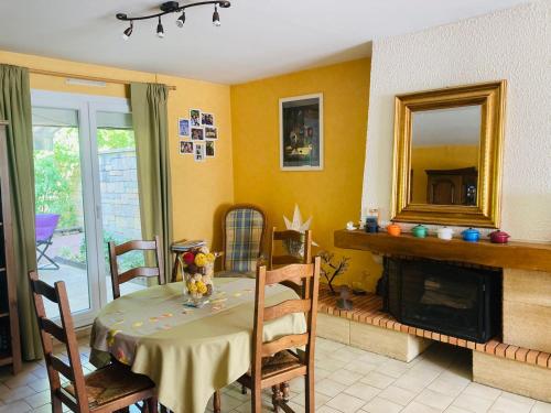 ein Esszimmer mit einem Tisch und einem Kamin in der Unterkunft Chambre chez l'habitant. in Metz
