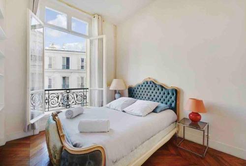 Champs Élysées : Appartement 200 m2 avec balcon في باريس: غرفة نوم بسرير مع نافذة كبيرة