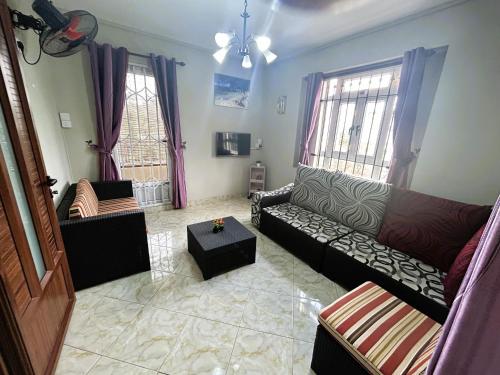 a living room with a couch and two windows at Apartment Huz Peer 2 in Trou aux Biches
