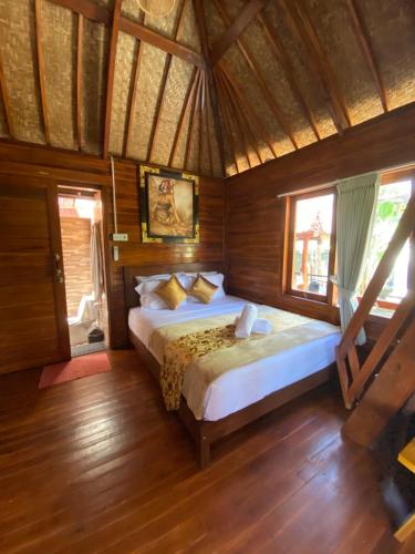 1 dormitorio con 1 cama grande en una habitación de madera en Pondok Biu, en Denpasar