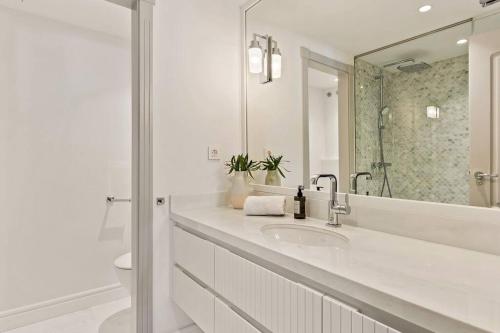 a white bathroom with a sink and a mirror at 2-Bedroom Apartment in Puente Romano, Marbella in Marbella