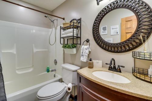 y baño con lavabo, aseo y espejo. en Stroudsburg Home with Hot Tub and Game Room!, en Stroudsburg