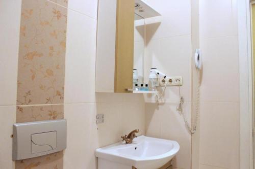 a white bathroom with a sink and a mirror at Hotel Santa Hill in Istanbul