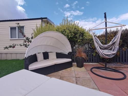 a hammock and a couch in a yard at Lakes and woodlands hiking Overstone Holiday Park in Sywell