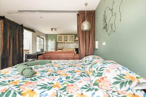 a bedroom with a bed with a floral comforter at Bed & Bike Harbour Hoorn in Hoorn
