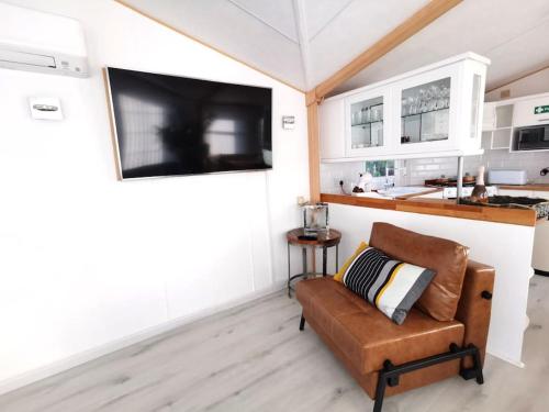 a living room with a couch and a flat screen tv at Lakes and woodlands hiking Overstone Holiday Park in Sywell