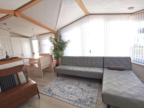 a living room with a couch and a table at Lakes and woodlands hiking Overstone Holiday Park in Sywell