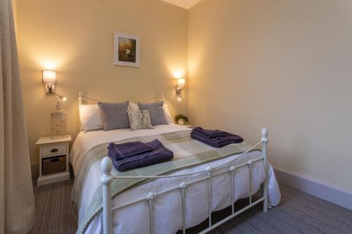a bedroom with a bed with two towels on it at Howgills House Hotel in Sedbergh