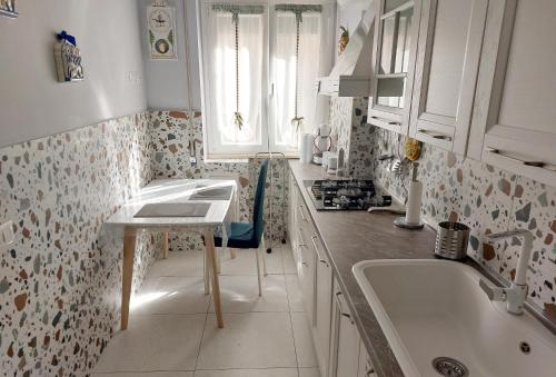 a white kitchen with a sink and a window at Tra le antiche mura e Garbatella in Rome