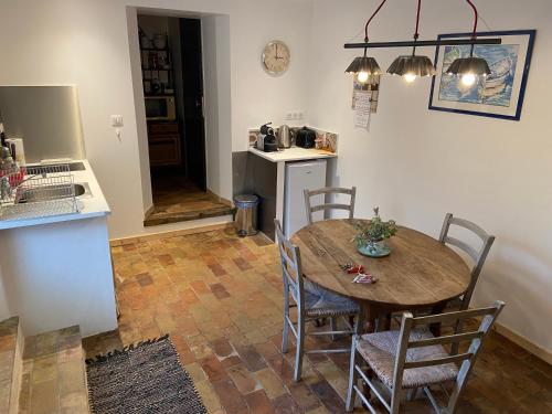 une cuisine et une salle à manger avec une table et des chaises en bois dans l'établissement Le vieux fournil, à Noyers-sur-Jabron
