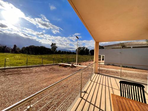 une terrasse en bois avec vue sur un champ dans l'établissement Bel appartement Corse côte Est, à Morta