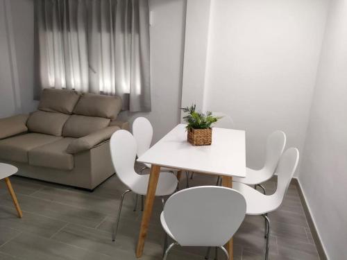 een woonkamer met een tafel en stoelen en een bank bij Apartamento vacacional en Denia in Denia