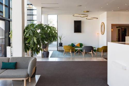 a living room with chairs and a table at Holiday Inn - Marseille Airport by IHG in Vitrolles
