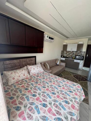 um quarto com uma cama grande e um sofá em zooz home vacation em El Alamein