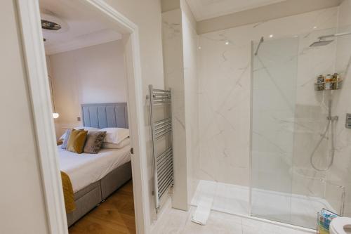 uma casa de banho com um chuveiro, uma cama e um chuveiro em WENSLEYDALE, OLD SCHOOL ROOMS - Ground Floor Luxury Apartment in Richmond, North Yorkshire em Richmond