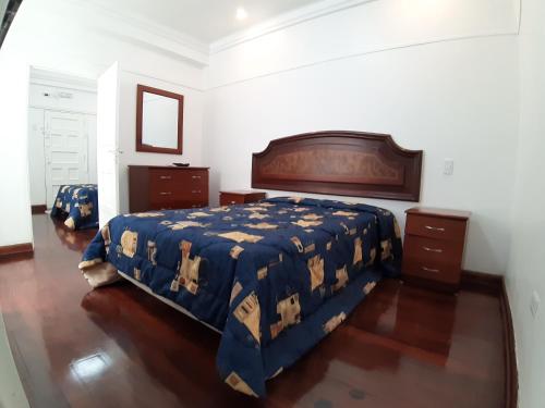 a bedroom with a bed with a blue comforter at APARTAMENTO LINDO - A 2 Cuadras de la Plaza de Armas y del Palacio de Gobierno in Lima