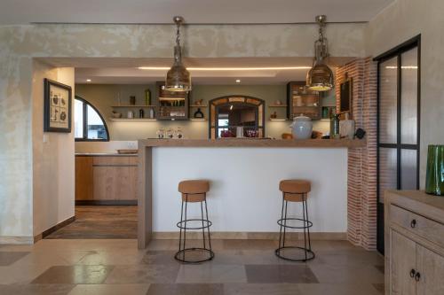 a kitchen with two stools at a bar at LA BASTIDE DES CULS-ROUSSET in Marseille