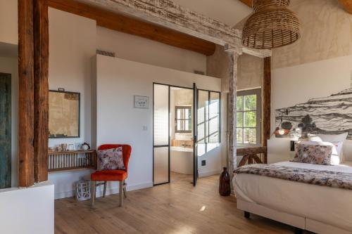 um quarto com uma cama e uma cadeira em LA BASTIDE DES CULS-ROUSSET em Marselha